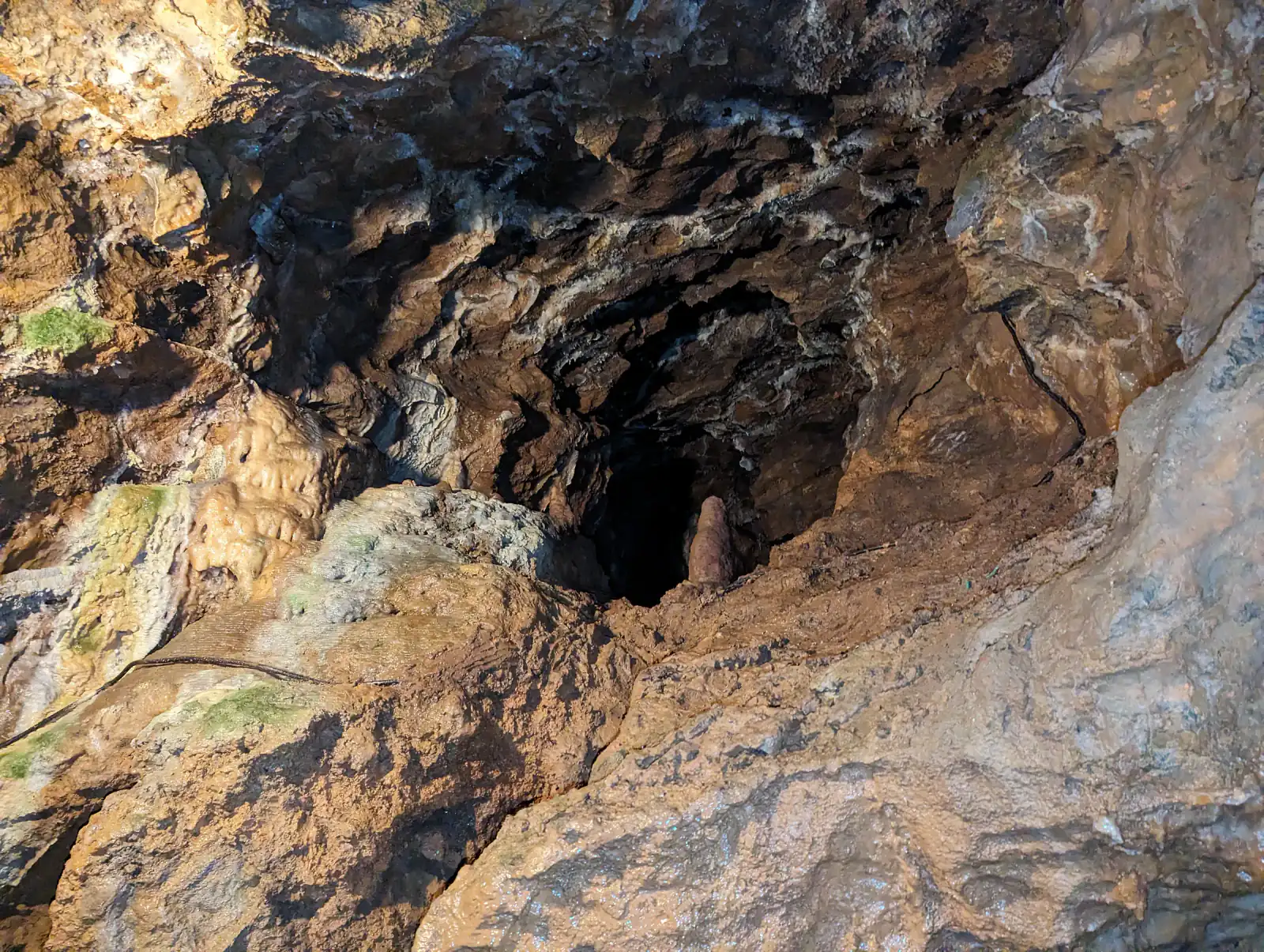 Enger Gang mit Lampe in der Tropfsteinhöhle