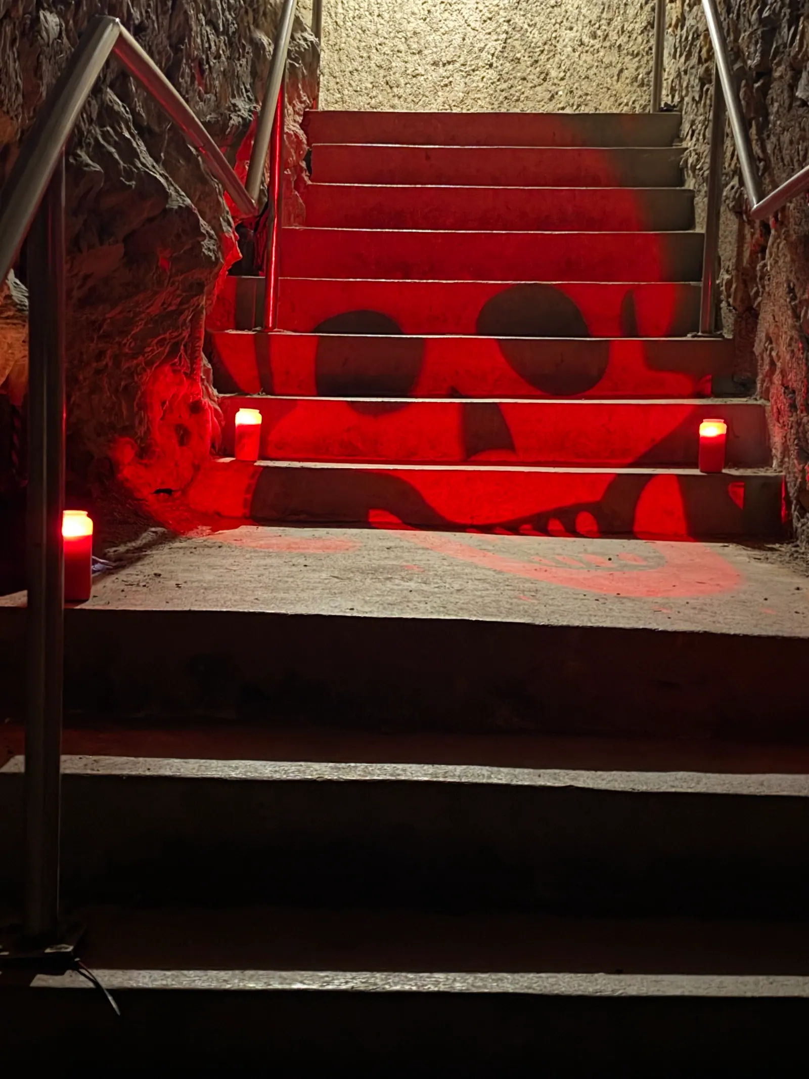Red-lit stairs with a skull pattern and candles