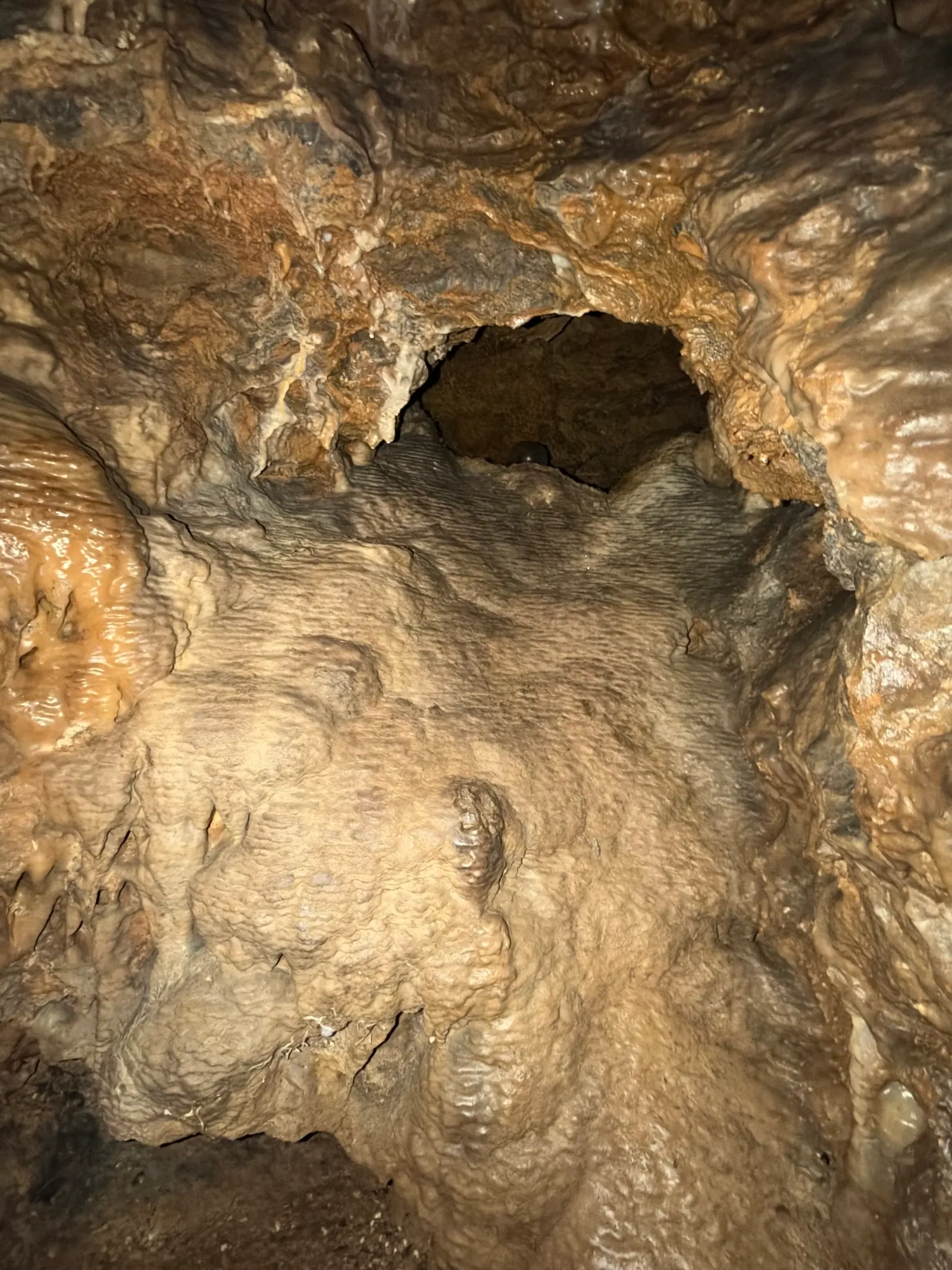 Sinterwand mit einer Öffnung in der Tropfsteinhöhle