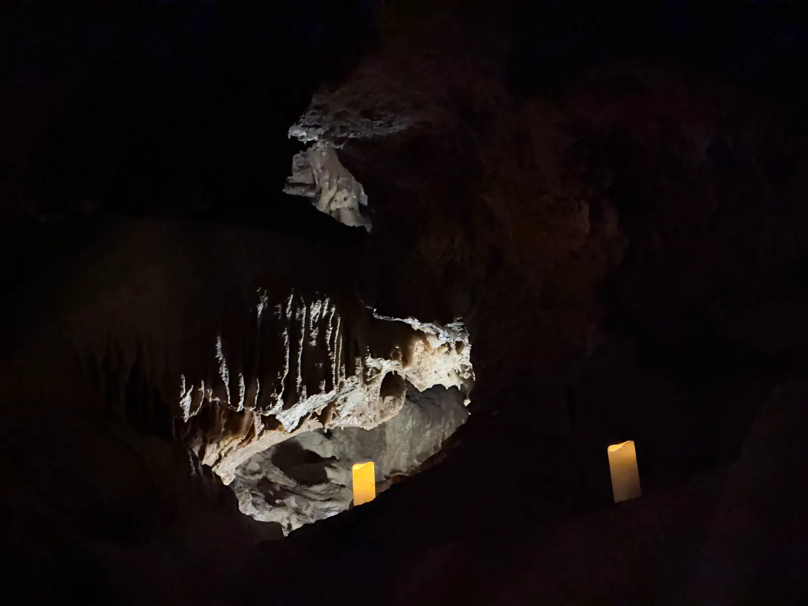 Beleuchteter Stalaktitenkranz mit einer Kerze in der Tropfsteinhöhle