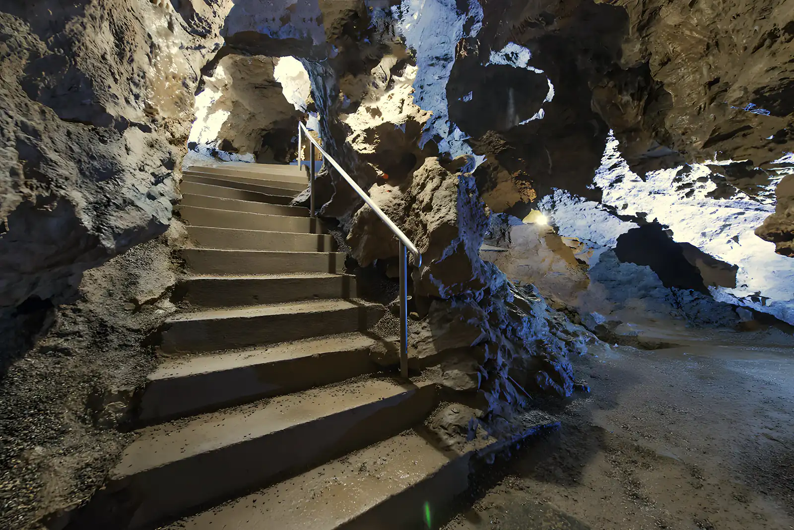 Treppe mit Geländer führt zwischen Felswänden in die Tropfsteinhöhle